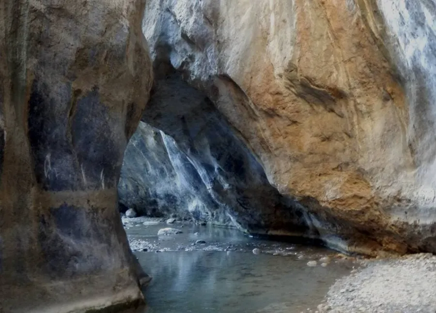 Narrow canyon passage with stones and shallow water at Sarakina Gorge