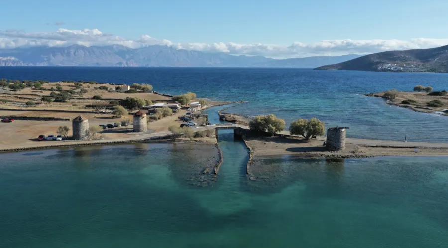 Old windmills near the coastline of Elounda overlooking the water
