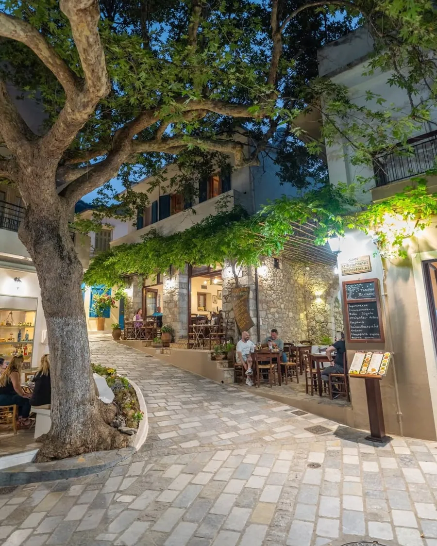 Tables under a large plane tree in the courtyard of Taverna Platanos in Kritsa